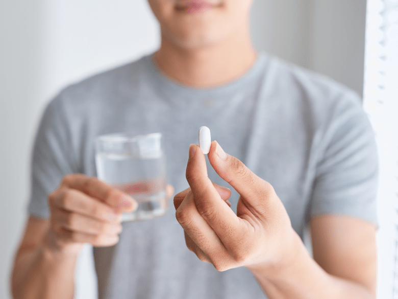 man holding a Weiprost capsule for prostatitis